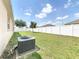 Well-maintained backyard featuring a white fence, lush green lawn, and an air conditioning unit at 236 Barrington Dr, Haines City, FL 33844