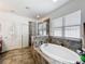 This bathroom features a soaking tub, a tiled glass shower, and a window at 236 Barrington Dr, Haines City, FL 33844