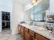 Double sink bathroom with wood cabinets and access to a walk-in closet at 236 Barrington Dr, Haines City, FL 33844
