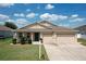 Charming single-story home featuring a three-car garage, well-maintained lawn, and a cozy front porch at 236 Barrington Dr, Haines City, FL 33844