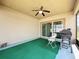 Covered patio area with a ceiling fan, outdoor chairs, grill, and sliding glass door access at 236 Barrington Dr, Haines City, FL 33844