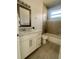 Bright bathroom featuring a single sink vanity with white cabinets and a bathtub with tiled walls at 388 Chinaberry Ave, Oviedo, FL 32765