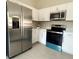 Modern kitchen with stainless steel appliances, white cabinets, and light countertops at 388 Chinaberry Ave, Oviedo, FL 32765