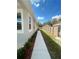 Narrow side yard with a tidy walkway, lush green grass, and a well-maintained wooden fence at 388 Chinaberry Ave, Oviedo, FL 32765