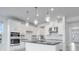 Modern kitchen with stainless steel appliances, white cabinetry, a black countertop island, and pendant lighting at 4723 Coral Harbour Rd, Kissimmee, FL 34758