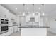 Modern kitchen with stainless steel appliances, white cabinetry, a black countertop island, and pendant lighting at 4723 Coral Harbour Rd, Kissimmee, FL 34758