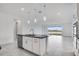 Bright kitchen with stainless steel appliances, white cabinets, black countertop island and pendant lighting at 4723 Coral Harbour Rd, Kissimmee, FL 34758
