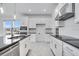 Well-lit kitchen featuring stainless steel appliances, white cabinets with black counters and tile backsplash at 4723 Coral Harbour Rd, Kissimmee, FL 34758