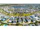 Stunning aerial view of a Primary-planned community featuring a lake, homes, and green spaces at 8279 Nemours Pkwy, Orlando, FL 32827