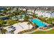 A fantastic community pool with multiple pools, lounge chairs, palm trees, and a volleyball court at 8279 Nemours Pkwy, Orlando, FL 32827