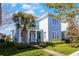 Inviting two-story home featuring a covered porch, well-maintained lawn, and lush landscaping at 8279 Nemours Pkwy, Orlando, FL 32827