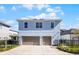 Rear view of a two-story home with a two car garage and a fenced backyard at 8279 Nemours Pkwy, Orlando, FL 32827