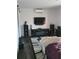 Modern living room with dark floors, electric fireplace, and large TV at 910 Rangeline Rd, Longwood, FL 32750