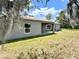 View of covered back porch with exterior paint, nice yard and view of blue sky at 1202 Alafia Way, Poinciana, FL 34759
