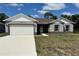 Charming single-story home with a well-manicured lawn, a spacious driveway, and a two-car garage at 1314 Hillsborough Ct, Poinciana, FL 34759