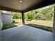 Covered patio area overlooking a large yard and surrounding trees at 1314 Hillsborough Ct, Poinciana, FL 34759