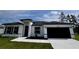 Charming single-story home with a white exterior, dark roof, and well-manicured lawn at 3041 Sw 168Th Loop, Ocala, FL 34473