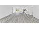 Spacious living room with gray wood-look floors leading into a bright, modern kitchen at 3041 Sw 168Th Loop, Ocala, FL 34473