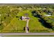 Expansive aerial view of property with pond, mature trees, and verdant lawn at 3145 Packard Ave, St Cloud, FL 34772