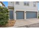 Modern two-story home featuring a gray garage door, landscaped yard, and a welcoming side entrance at 7951 Nemours Pkwy, Orlando, FL 32827