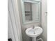 Pedestal sink with decorative mirror in a well-lit, neutral-toned powder room at 3207 Stratton Cir, Kissimmee, FL 34744