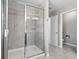 Bathroom featuring a glass shower, white walls and door, and gray tile flooring at 3207 Stratton Cir, Kissimmee, FL 34744