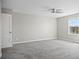 Bright bedroom features a ceiling fan, neutral paint, carpeted floor and large window at 3207 Stratton Cir, Kissimmee, FL 34744