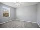 Neutral bedroom featuring gray walls, plush carpet, ceiling fan, and bright natural light from a sunny window at 3207 Stratton Cir, Kissimmee, FL 34744