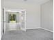 Carpeted bedroom with bright light from the patio doors, neutral paint, and a view to the yard at 3207 Stratton Cir, Kissimmee, FL 34744