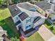 Charming two-story home with a well-manicured lawn, brick driveway, and bright blue shutters at 3207 Stratton Cir, Kissimmee, FL 34744