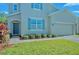 Two-story home showcasing a two car garage, blue shutters, landscaped yard, and brick driveway at 3207 Stratton Cir, Kissimmee, FL 34744