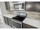 Stainless steel oven and stovetop sit next to dark colored kitchen cabinets at 3207 Stratton Cir, Kissimmee, FL 34744