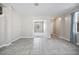 Bright living room with neutral walls, tile floors, and open doorway to another room at 3207 Stratton Cir, Kissimmee, FL 34744