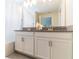 Well-lit bathroom features a double vanity with elegant fixtures, and a shower-tub combo with a curtain at 8943 Cabot Cliffs Dr, Davenport, FL 33896