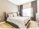 Calm bedroom featuring a queen bed with neutral bedding, designer wallpaper, and elegant curtains at 8943 Cabot Cliffs Dr, Davenport, FL 33896