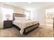 Cozy main bedroom features a plush king bed, soft carpet, and serene ambiance with access to bathroom at 8943 Cabot Cliffs Dr, Davenport, FL 33896