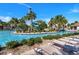 Resort-style pool area featuring lounge chairs, palm trees, pool slide, and clear blue water on a sunny day at 8943 Cabot Cliffs Dr, Davenport, FL 33896