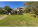 House back view with stone path, lush lawn, and fenced area at 2115 Lake Crescent Ct, Windermere, FL 34786