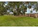 Spacious backyard with mature trees and partial view of lake at 510 Cranes Way # 306, Altamonte Springs, FL 32701