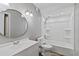 Clean, white bathroom with tub shower, a round mirror and modern fixtures at 510 Cranes Way # 306, Altamonte Springs, FL 32701