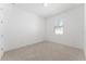 Cozy bedroom features neutral walls and carpet, complemented by a window view at 15542 Sunquat Dr, Winter Garden, FL 34787