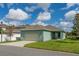 Attractive home exterior featuring a two-car garage, well-kept lawn, and inviting landscaping at 15542 Sunquat Dr, Winter Garden, FL 34787