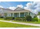 Charming single-story blue home with a well-manicured lawn, neat shrubbery, and a concrete walkway at 15542 Sunquat Dr, Winter Garden, FL 34787