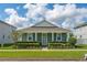 Charming single-story home with a blue exterior, well-manicured landscaping and a bright sunny sky at 15542 Sunquat Dr, Winter Garden, FL 34787