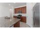 A spacious kitchen features a granite island with stainless steel appliances and wooden cabinets at 15542 Sunquat Dr, Winter Garden, FL 34787