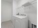 Functional laundry room with white appliances and shelving for organized storage at 15542 Sunquat Dr, Winter Garden, FL 34787