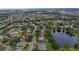 Aerial view of a suburban neighborhood with a pond and houses with private pools at 807 Grovesmere Loop, Ocoee, FL 34761