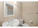 Well-lit bathroom featuring a pedestal sink, modern toilet, and a large framed mirror at 807 Grovesmere Loop, Ocoee, FL 34761