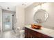 Modern bathroom with a unique sink, updated lighting, and a glass-enclosed shower next to a pool exit at 807 Grovesmere Loop, Ocoee, FL 34761