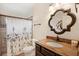 Bathroom with granite countertop, decorative mirror, and tiled shower with shower curtain at 807 Grovesmere Loop, Ocoee, FL 34761